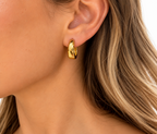 DUGO chunky huggie hoop earring in polished gold worn on a model for a minimalist everyday look.