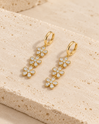 DUGO gold Crystal Flower Drop Earrings on travertine stone