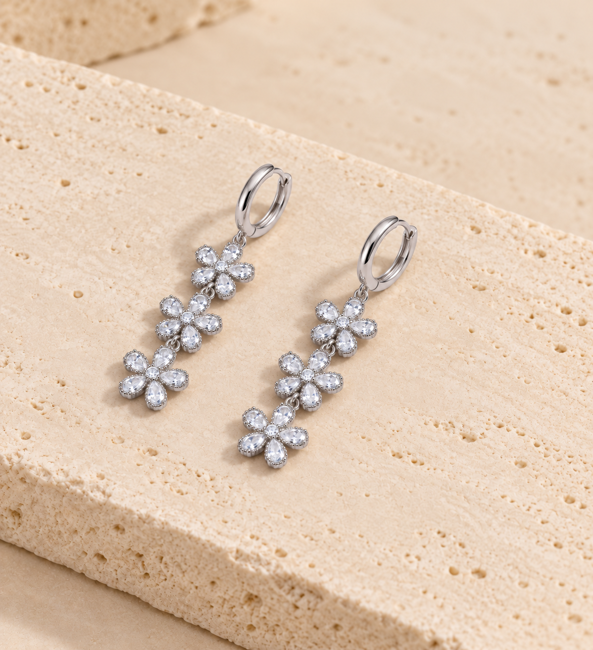 DUGO Crystal Flower Drop Earrings on travertine stone