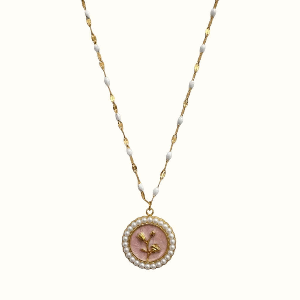 DUGO gold necklace featuring a round pendant with a pink flower motif surrounded by small white pearls on a beaded chain