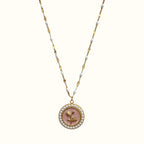 DUGO gold necklace featuring a round pendant with a pink flower motif surrounded by small white pearls on a beaded chain