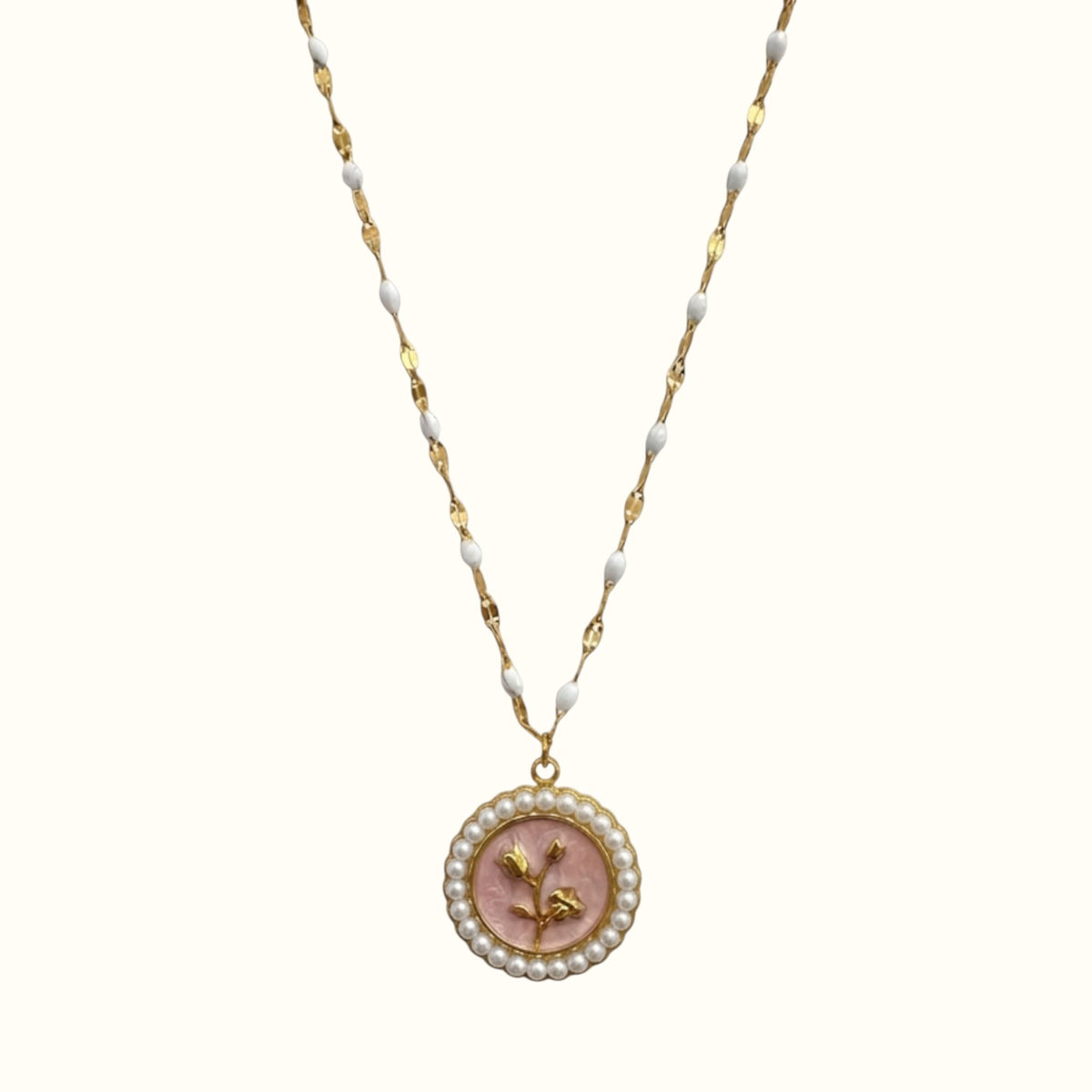 DUGO gold necklace featuring a round pendant with a pink flower motif surrounded by small white pearls on a beaded chain