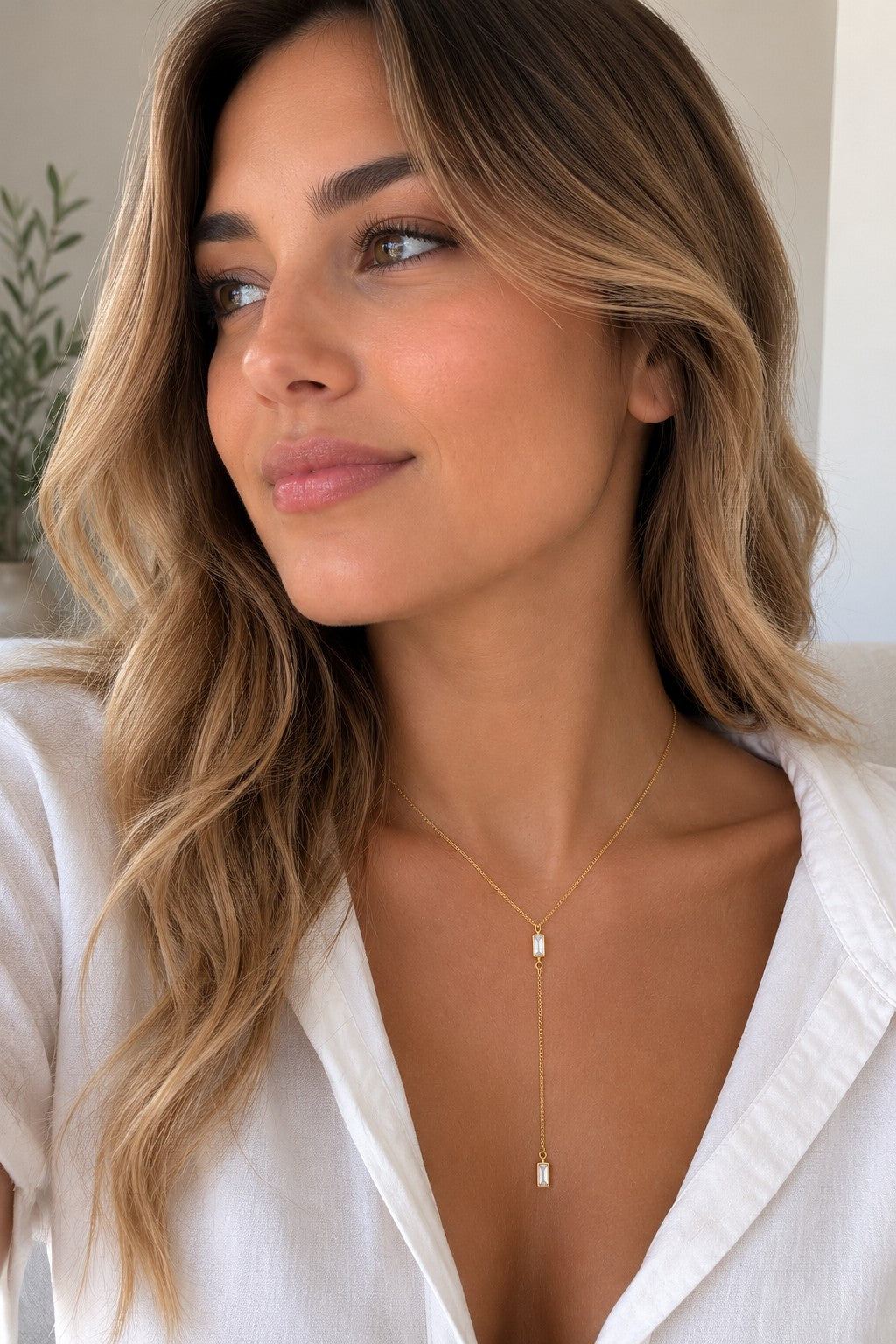Close-up of the DUGO gold Baguette Crystal Y Lariat Necklace worn on the neck