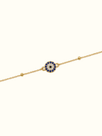 DUGO gold stainless steel evil eye bracelet with blue and white crystal accents on a delicate chain