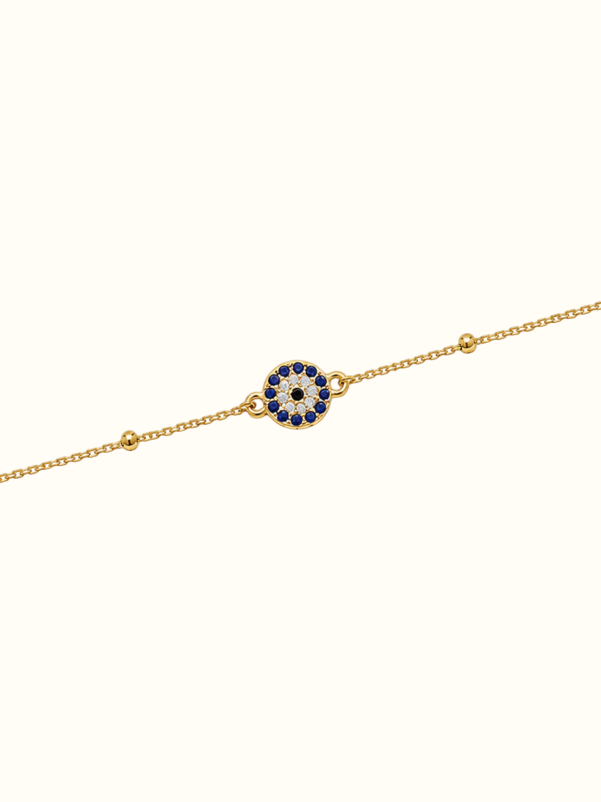DUGO gold stainless steel evil eye bracelet with blue and white crystal accents on a delicate chain