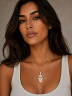 Close-up of the DUGO gold Hamsa Large Necklace worn on the neck