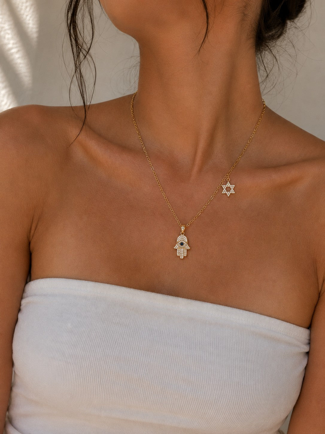 Woman wearing the DUGO gold Hamsa with Star David Charm Necklace