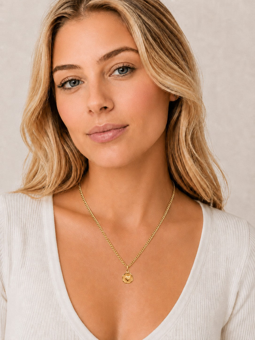 Close-up of the DUGO gold Heart Coin Necklace worn on the neck