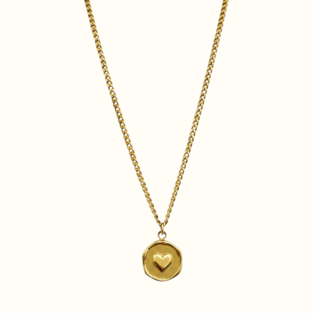 DUGO gold heart plate necklace featuring a delicate chain and a small embossed heart on a circular pendant
