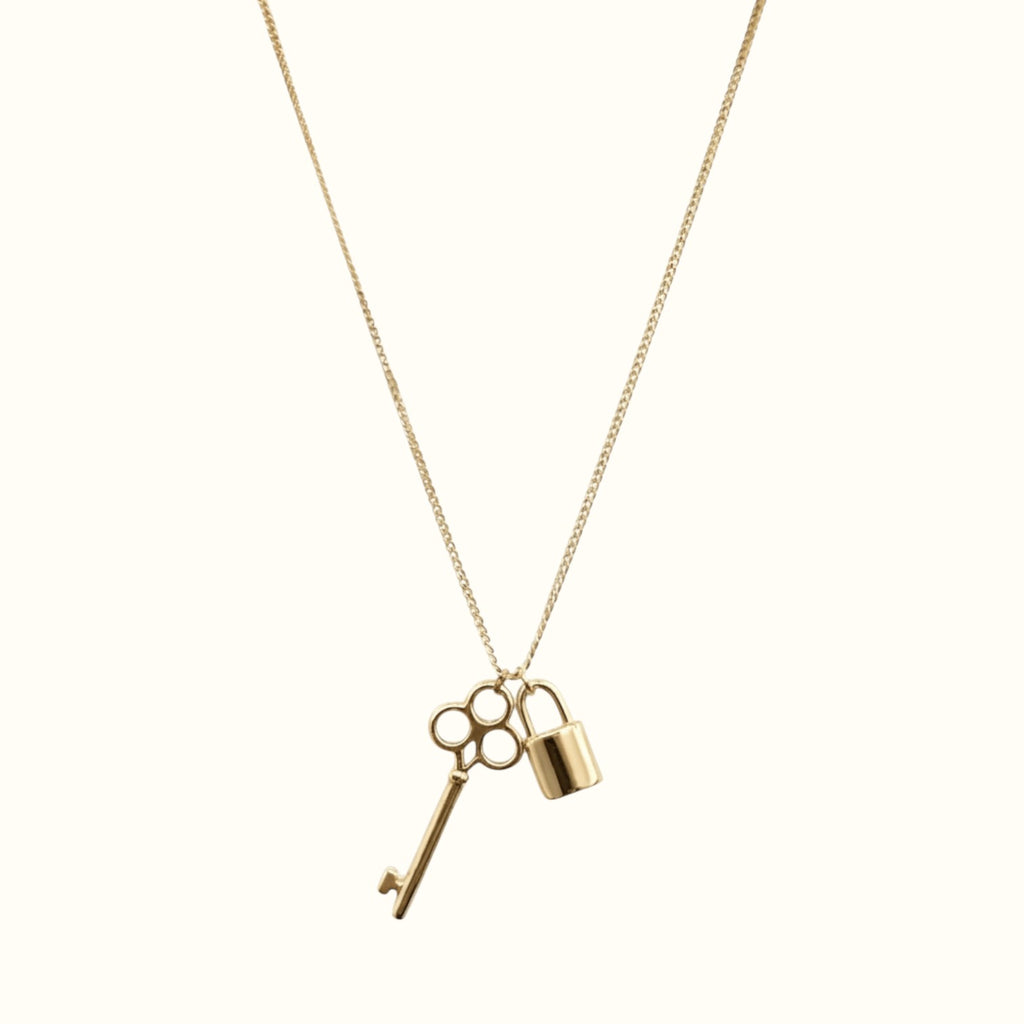 DUGO gold key and lock pendant necklace on a delicate chain, minimalist waterproof jewelry for everyday wear.