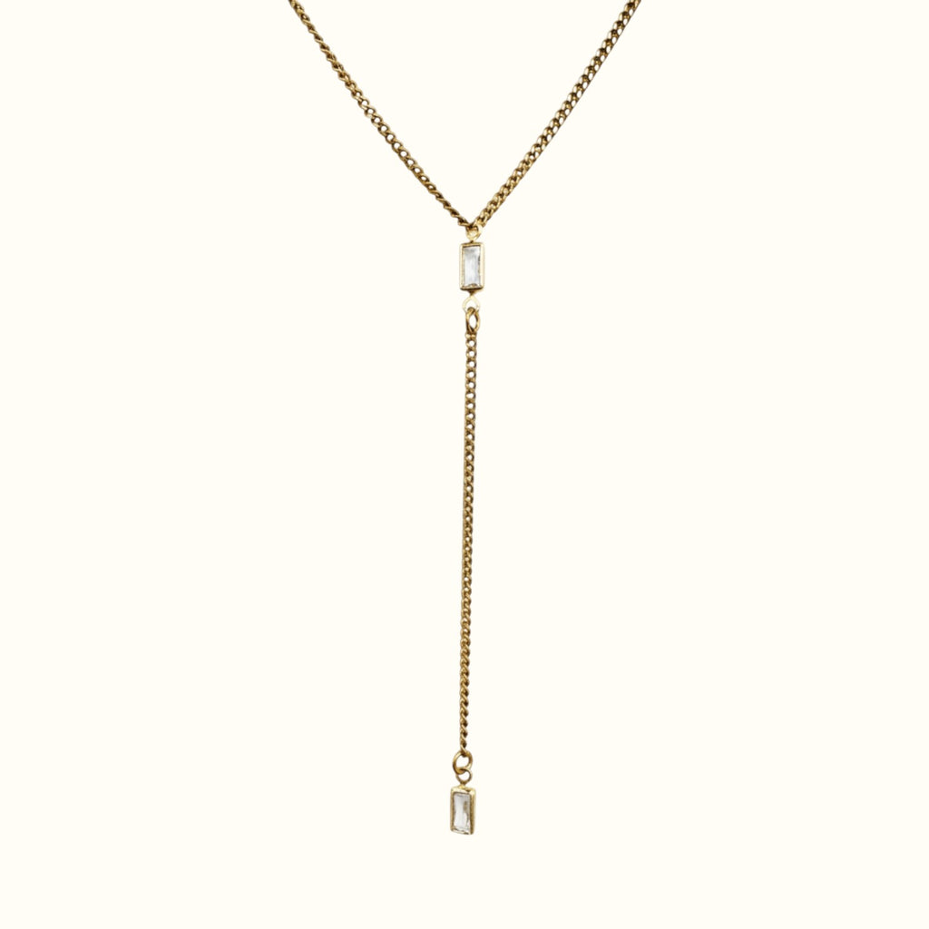DUGO gold lariat Y necklace featuring a thin Cuban chain and two clear baguette-cut cubic zirconia stones.