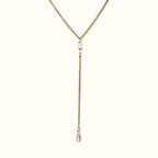 DUGO gold lariat Y necklace featuring a thin Cuban chain and two clear baguette-cut cubic zirconia stones.