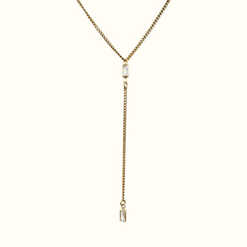 DUGO gold lariat Y necklace featuring a thin Cuban chain and two clear baguette-cut cubic zirconia stones.