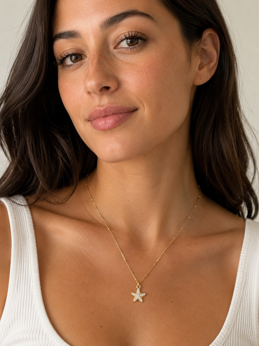 Close-up of the DUGO gold Pave Starfish Pendant Necklace worn on the neck