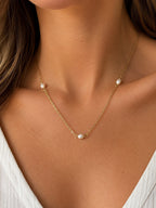 Woman wearing the DUGO gold Pearl Station Necklace