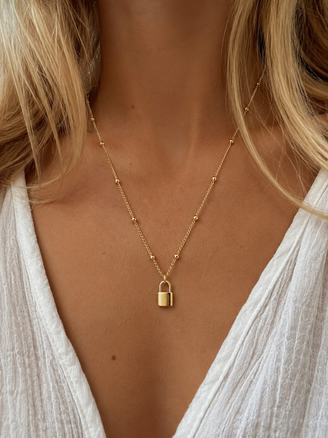 Woman wearing the DUGO gold Satellite Chain Padlock Necklace