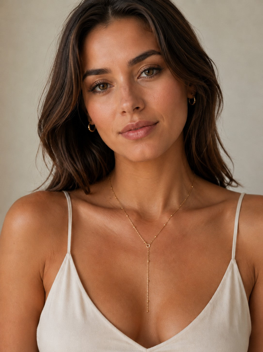 Close-up of the DUGO gold Satellite Chain Y Lariat Necklace worn on the neck