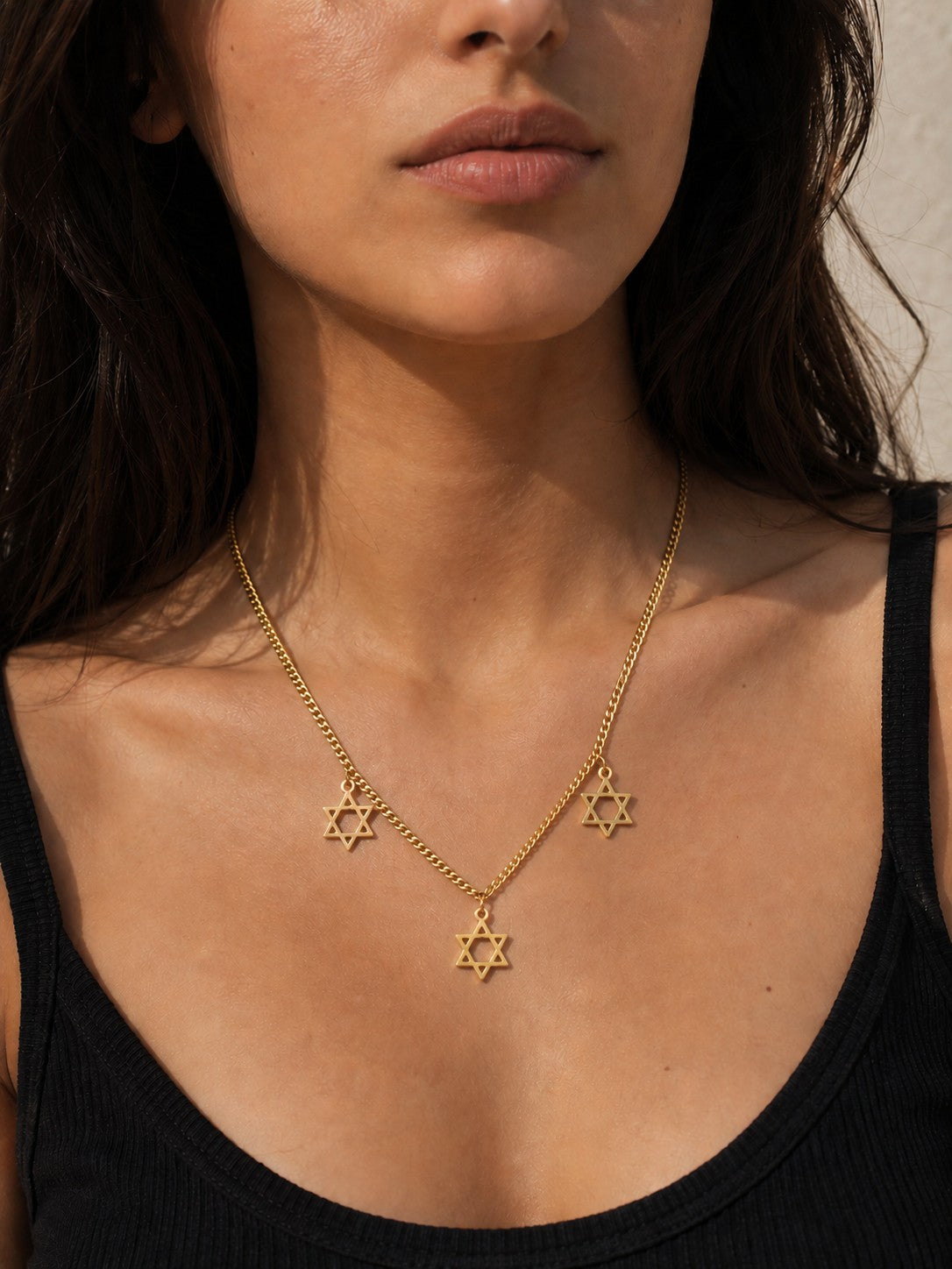 Woman wearing the DUGO gold Star David Classic Trio Necklace