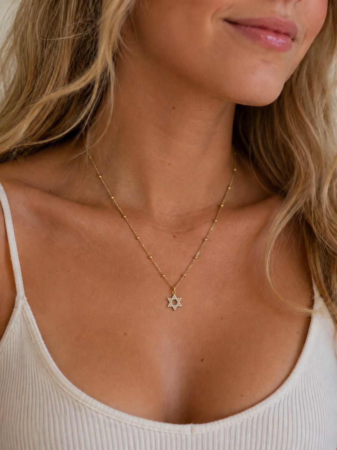 Woman wearing the DUGO gold Star David Necklace