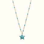 DUGO 18K gold-filled necklace featuring a blue enamel starfish pendant and matching turquoise bead chain accents.