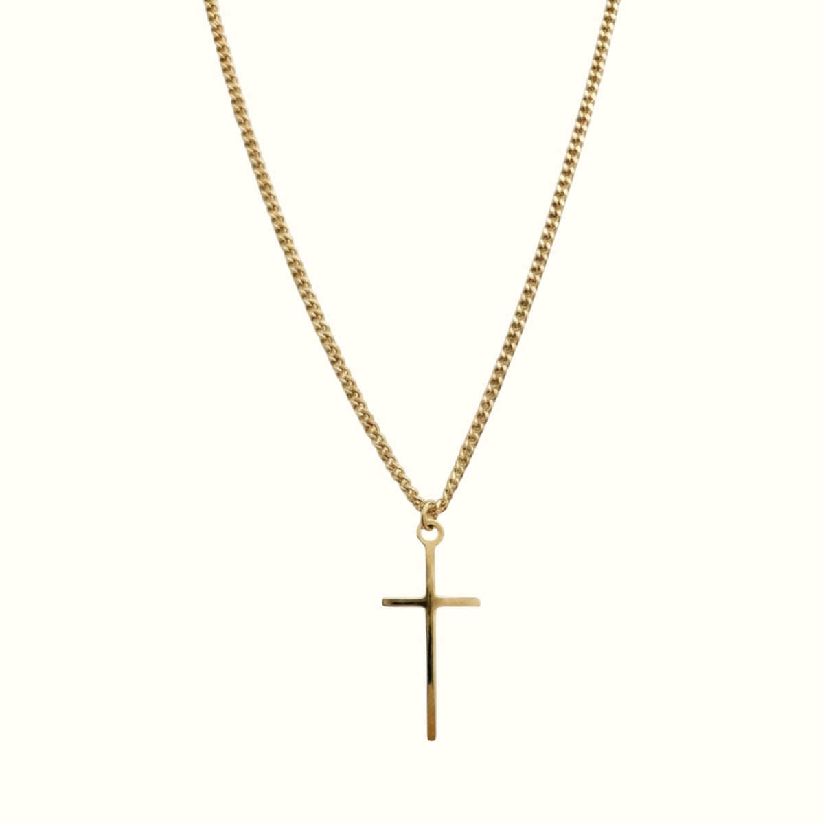 DUGO gold tiny cross pendant necklace on a delicate curb chain against a plain background