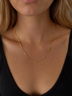 Close-up of the DUGO gold Tube Cable Chain Necklace worn on the neck