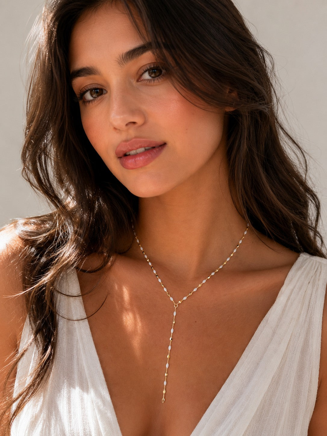 Close-up of the DUGO gold white Enamel Y Lariat Necklace worn on the neck