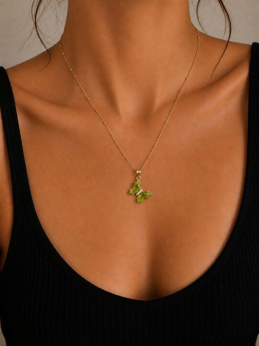 Close-up of the DUGO green Butterfly Lover Necklace worn on the neck