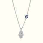 DUGO silver-tone Hamsa hand necklace with cubic zirconia, blue evil eye center, and matching charm on chain.