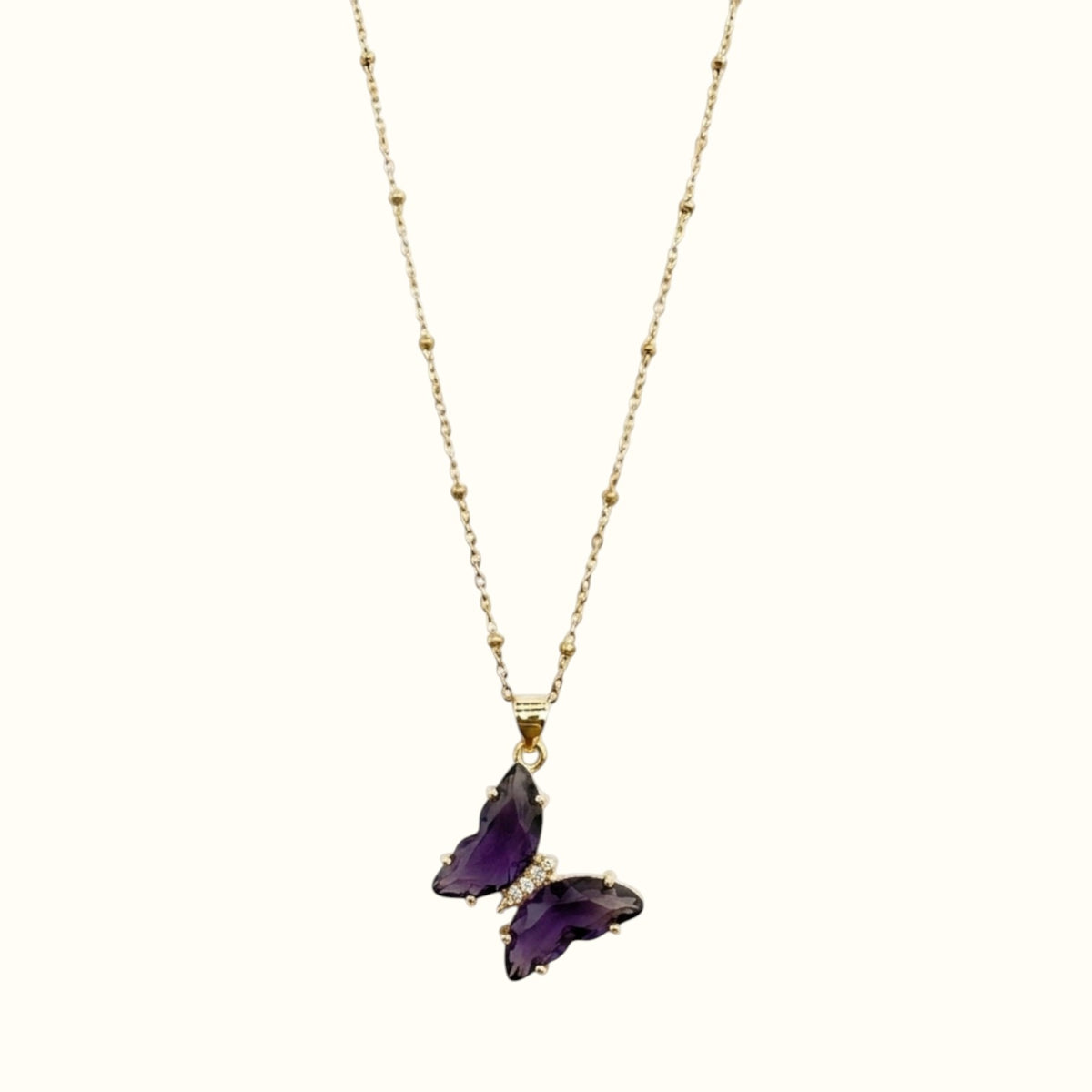 DUGO Butterfly Lover necklace featuring a purple crystal butterfly pendant with small clear stones on a gold chain.