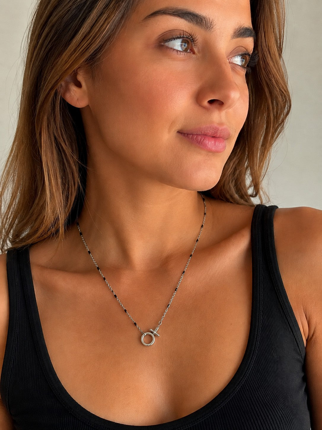 Close-up of the DUGO silver Black Enamel Spring Gate Necklace worn on the neck