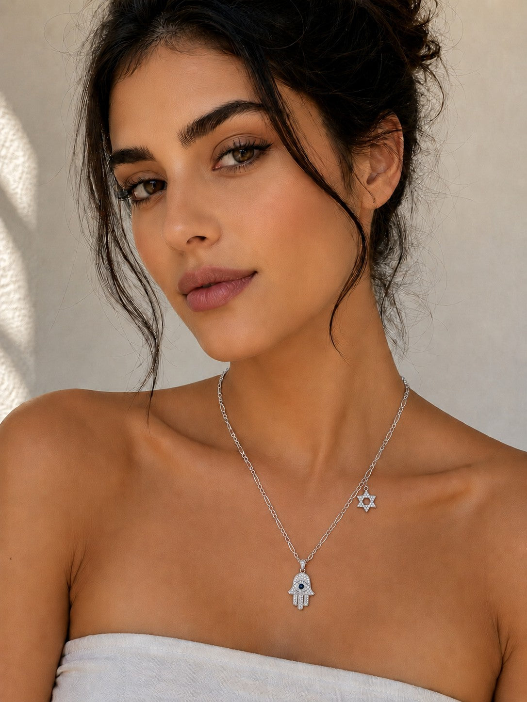 Close-up of the DUGO silver Hamsa with Star David Charm Necklace worn on the neck