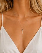 DUGO silver vintage key pendant on a dainty beaded ball chain worn by a woman in a white camisole