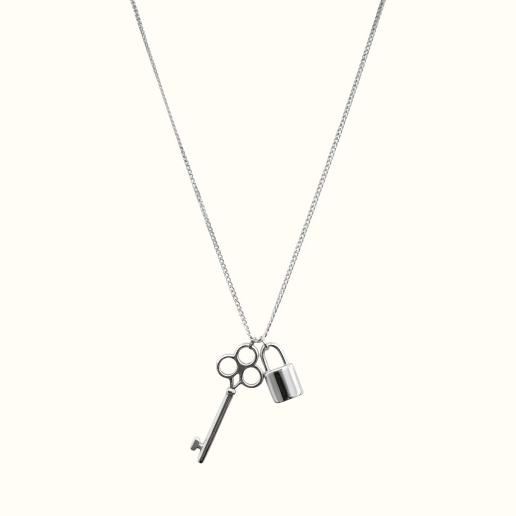 DUGO silver-tone key and lock pendant necklace on a delicate chain, minimalist waterproof jewelry for everyday wear.