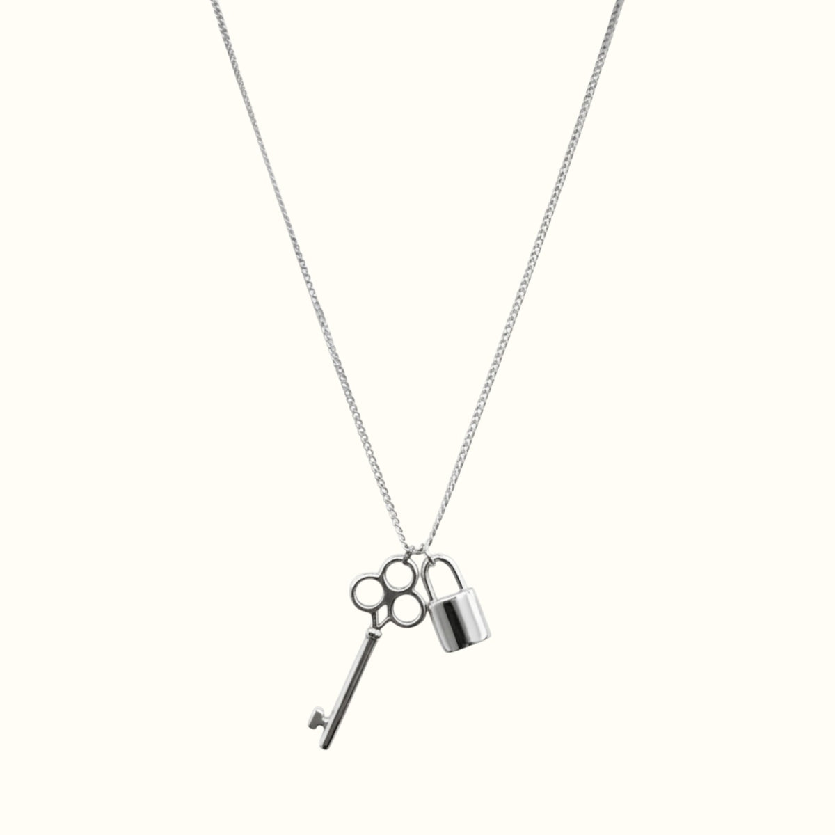 DUGO silver-tone key and lock pendant necklace on a delicate chain, minimalist waterproof jewelry for everyday wear.