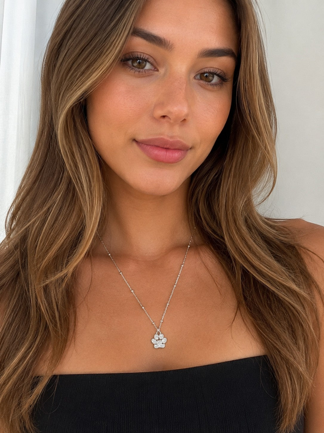 Close-up of the DUGO silver Paw Pendant Necklace worn on the neck