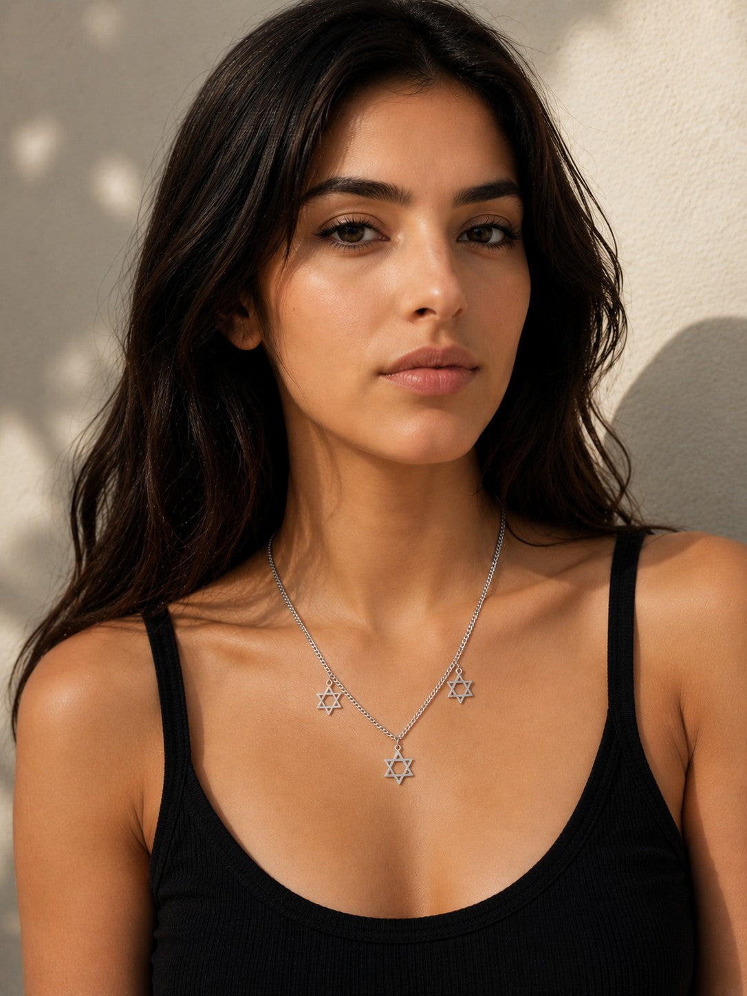 Close-up of the DUGO silver Star David Classic Trio Necklace worn on the neck