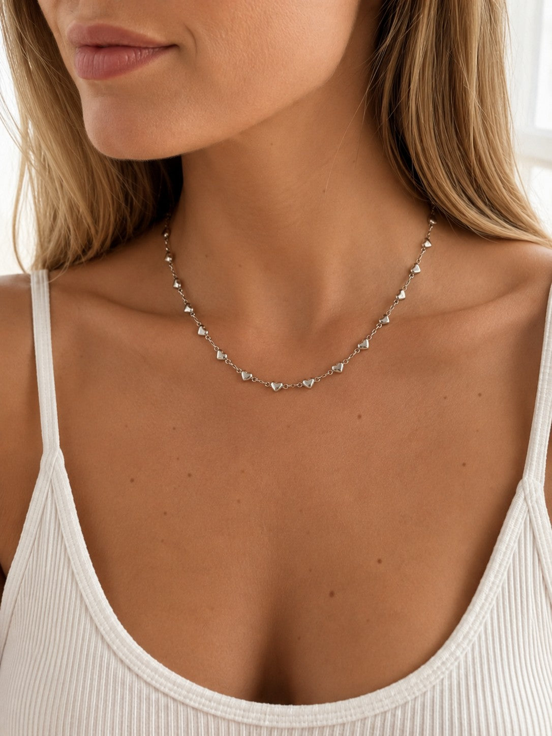 Close-up of the DUGO silver Tiny Heart Chain Necklace worn on the neck