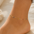 DUGO delicate gold chain anklet with tiny multicolor beads worn on an ankle, perfect for summer beach style.