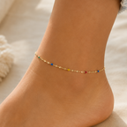 DUGO delicate gold chain anklet with tiny multicolor beads worn on an ankle, perfect for summer beach style.