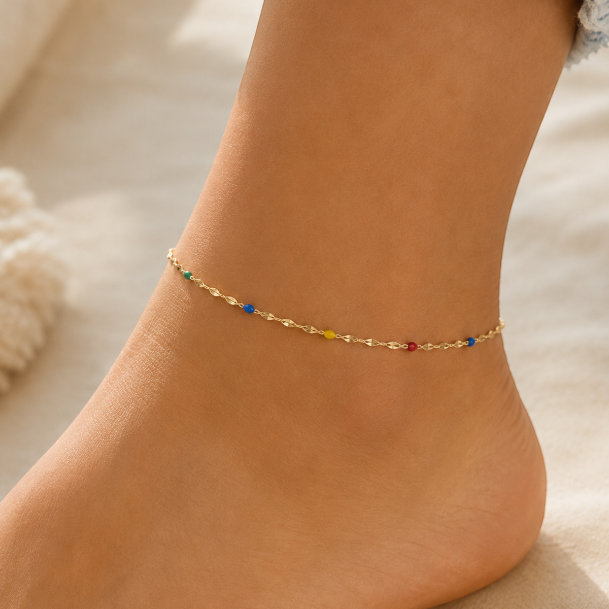 DUGO delicate gold chain anklet with tiny multicolor beads worn on an ankle, perfect for summer beach style.